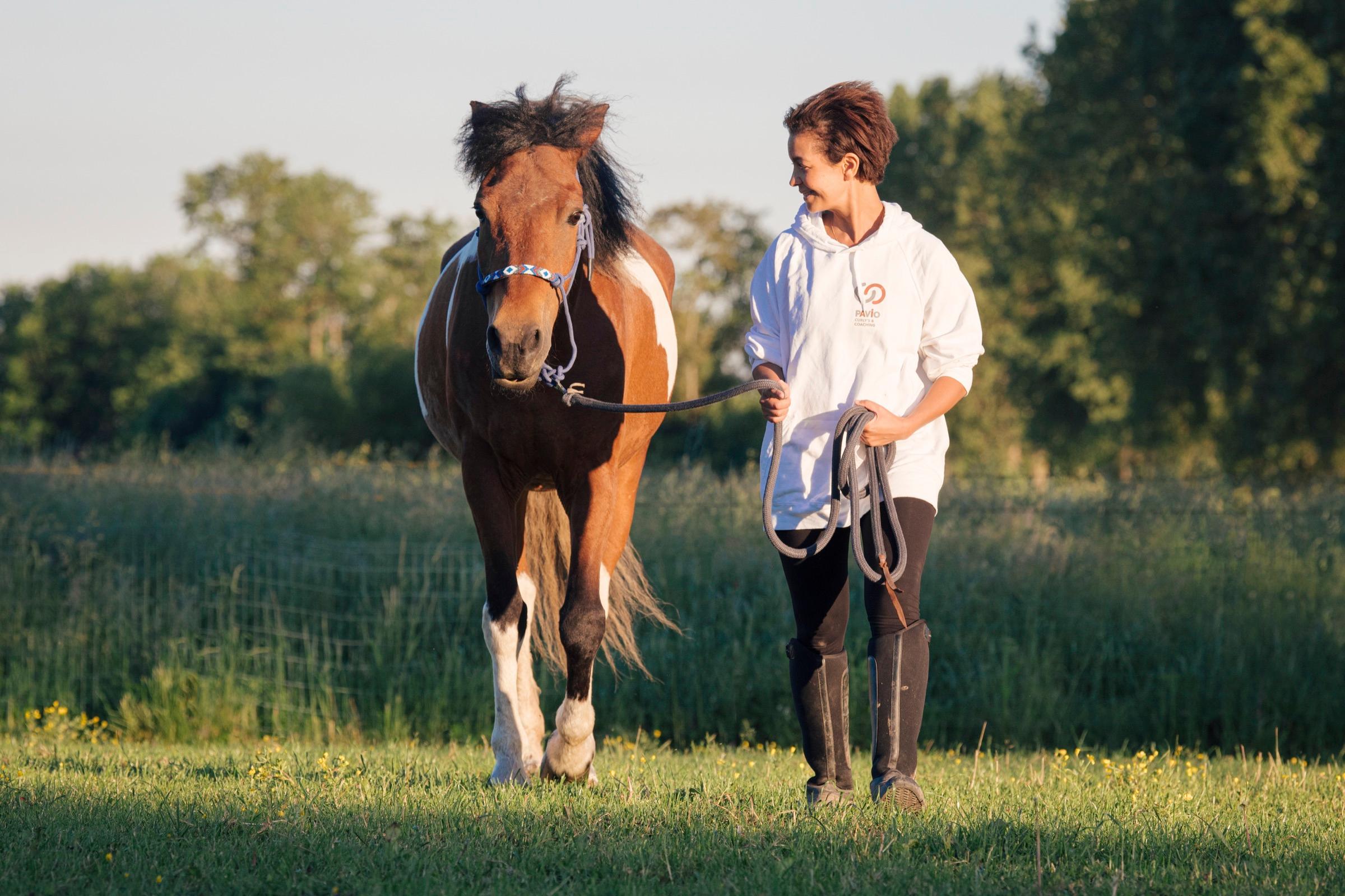 Vrouw in warm contact met haar Curly paard in het veld